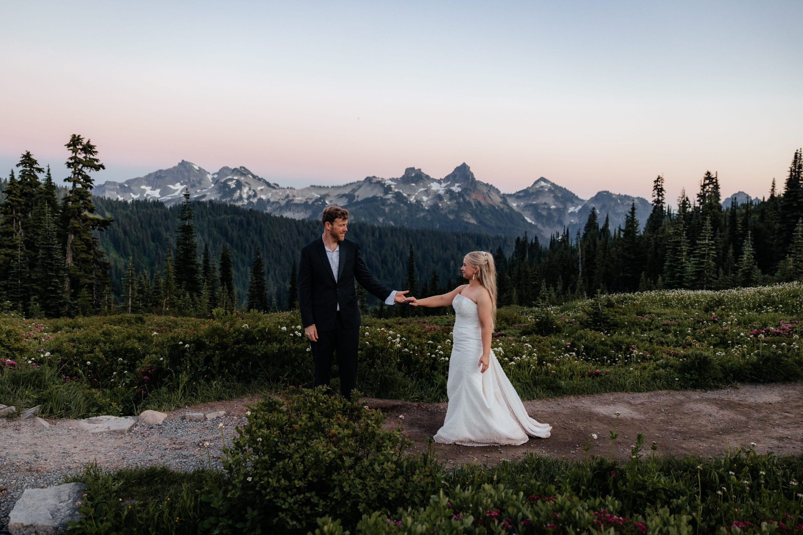 Newlyweds hold hands while hiking Skyline Trail in Mt Rainier National Park.