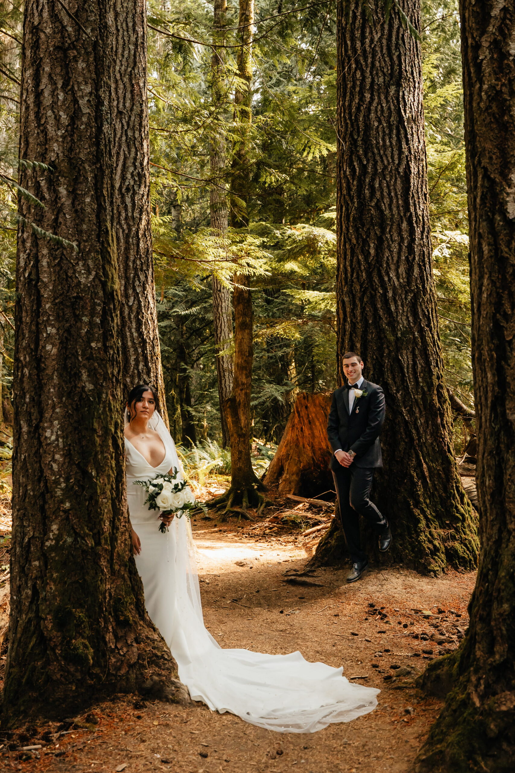 Bride and groom lean against the trees during their Hoh Rainforest elopement in Washington. 