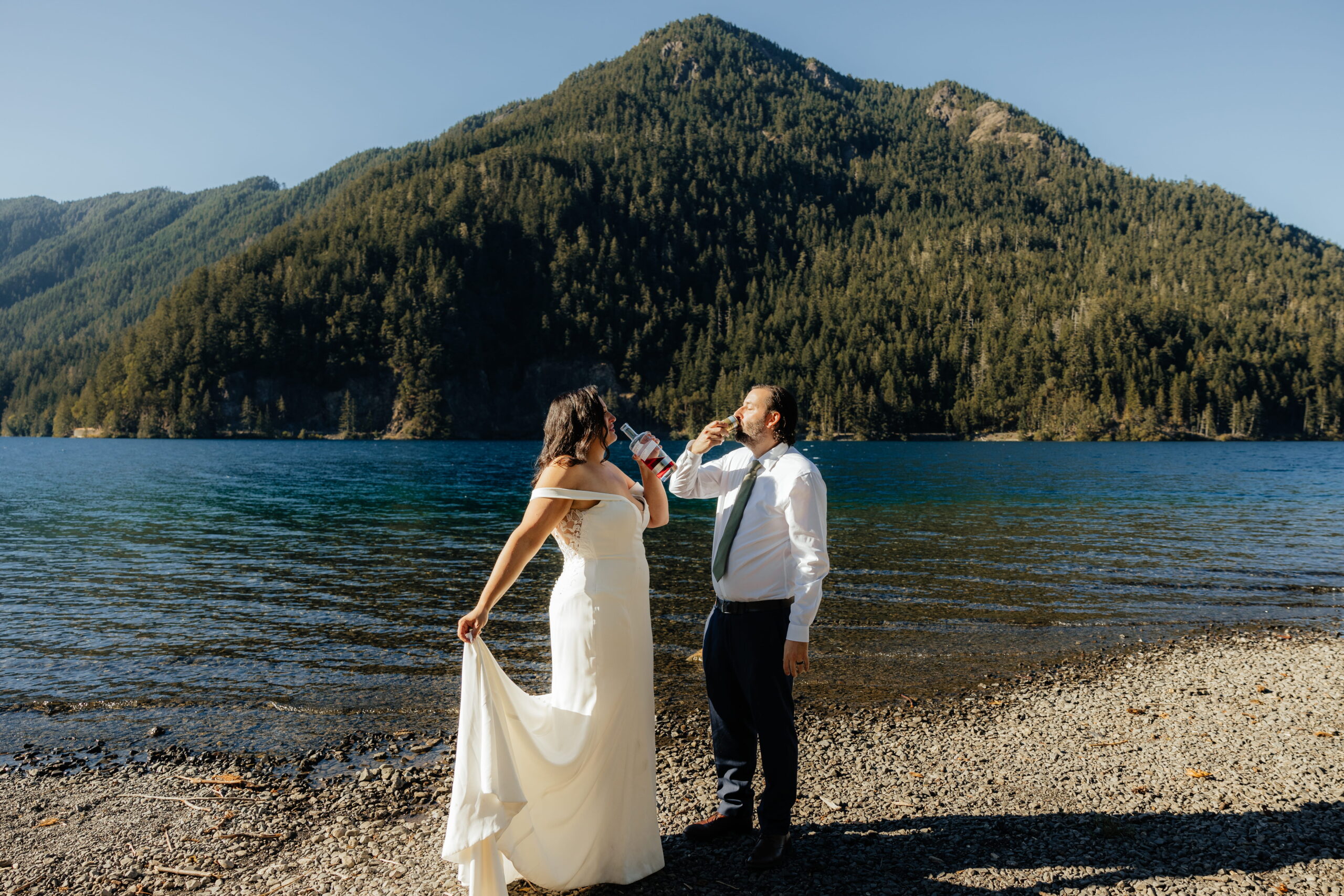 Newlyweds toast by the water during their Lake Crescent elopement reception. 