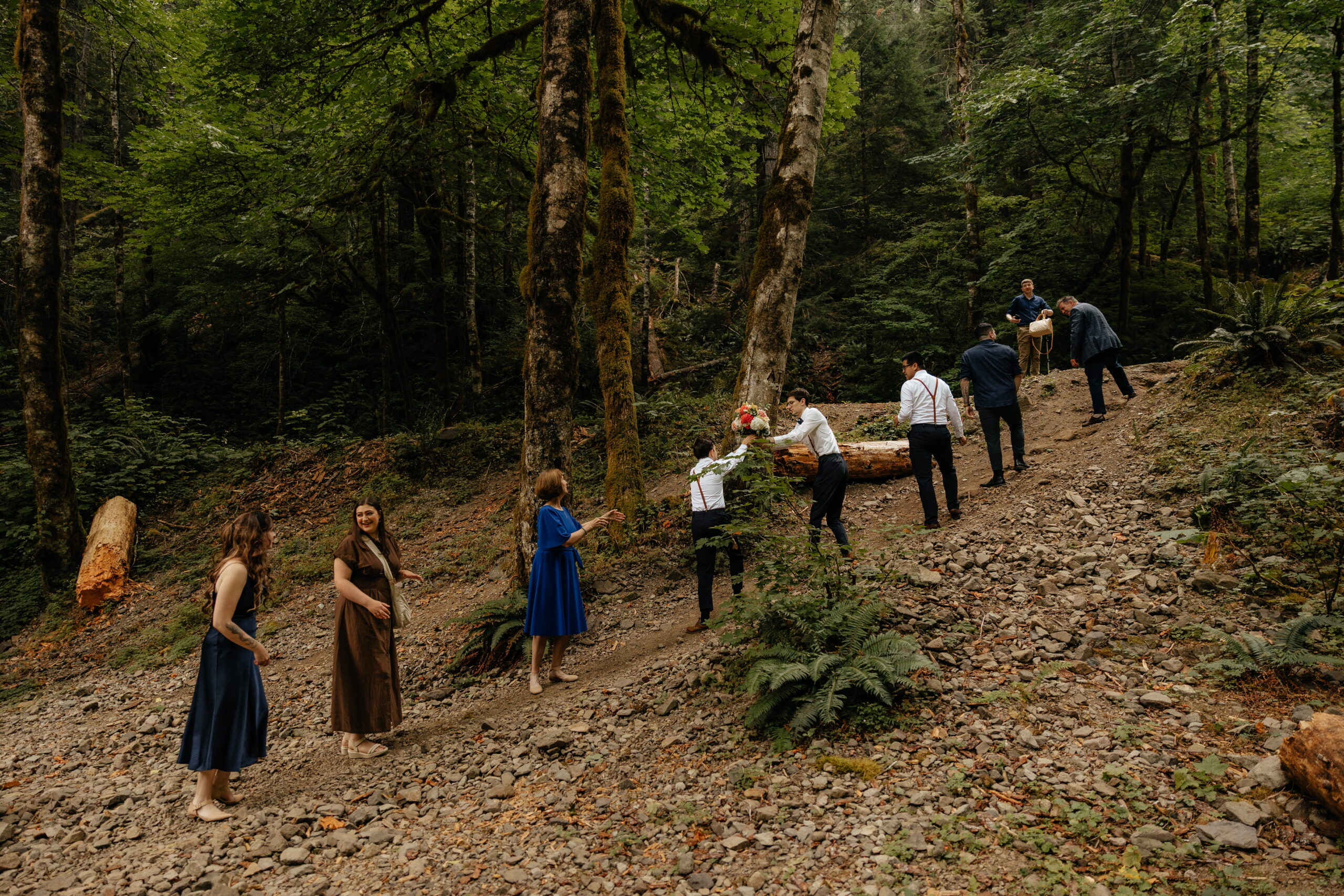 Guests walk a forest path to a Mt Rainier wedding ceremony site.