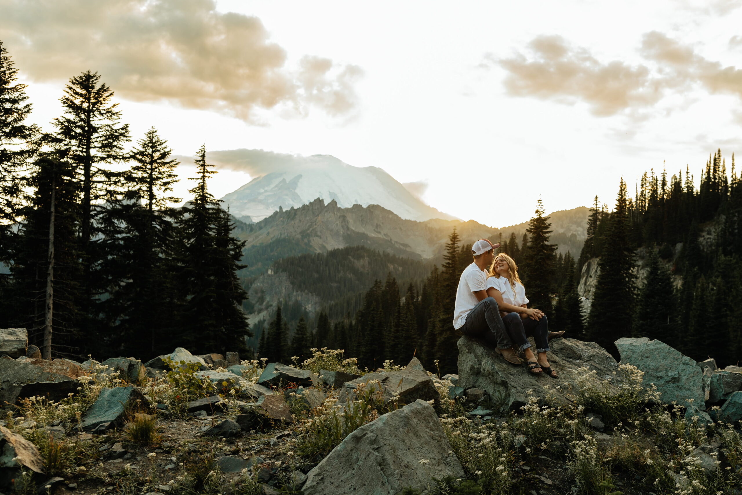 Couple perches on a mountain rock during their Sunrise Mt Rainier photo session.