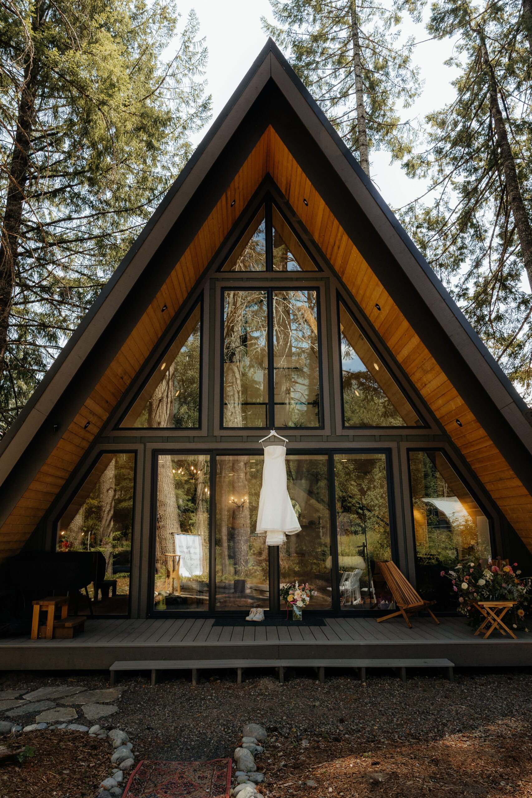 White wedding dress hangs from a glass front A-frame cabin near Mt Rainier National Park.