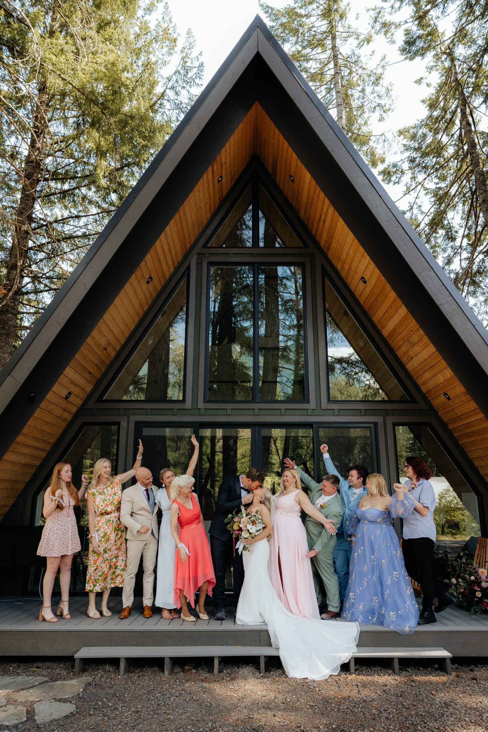 Guests cheer while newlyweds kiss on the front porch of their A-frame elopement cabin near Mt Rainier. 
