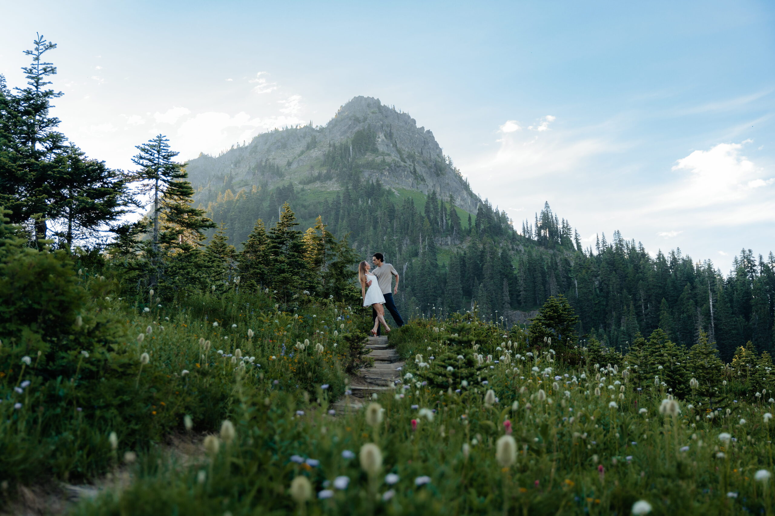 Couple stands on trail at Mt. Rainier National Park during summer.