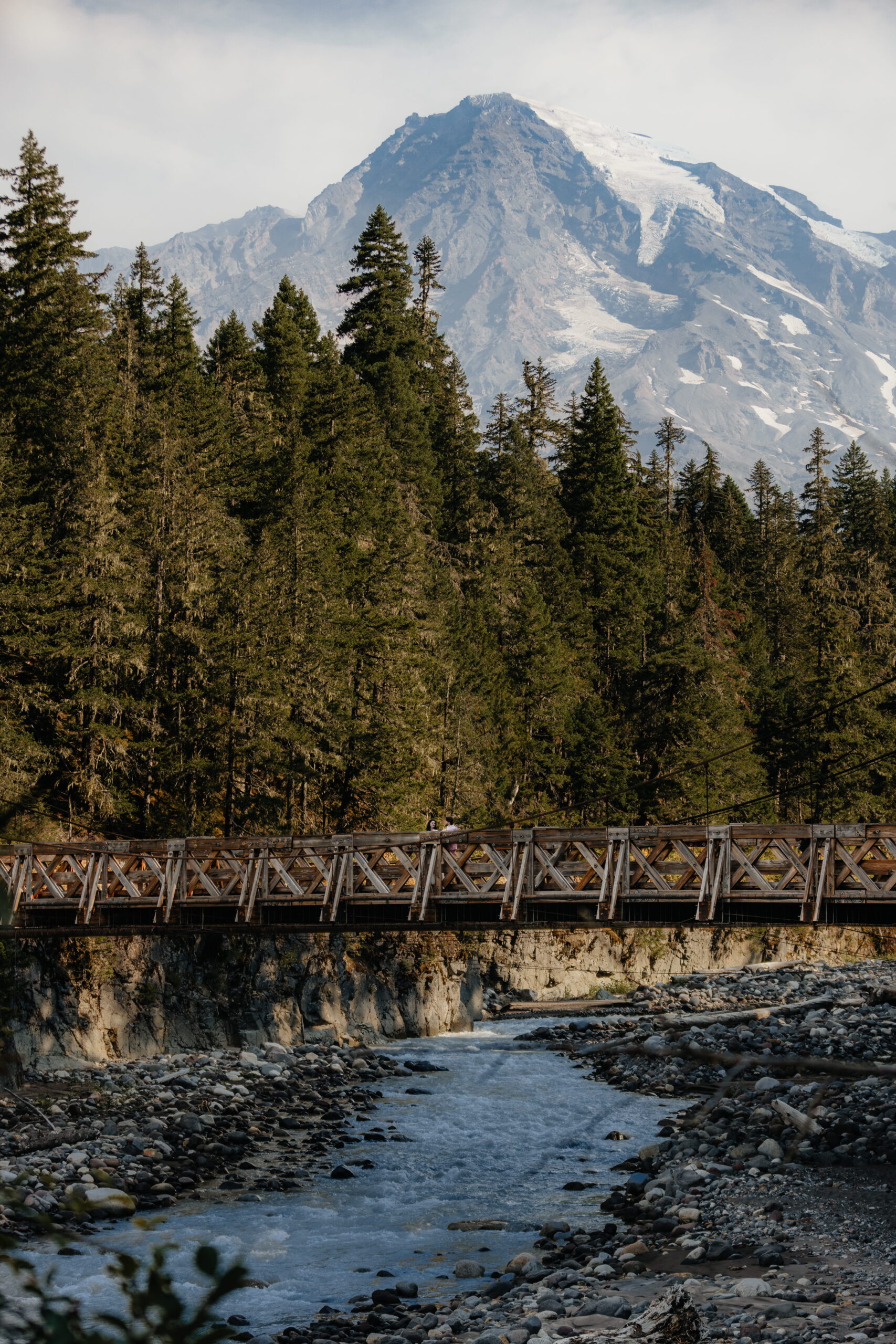 Newlyweds stand on a suspension bridge at Longmire, Mt. Rainier during their fall elopement.