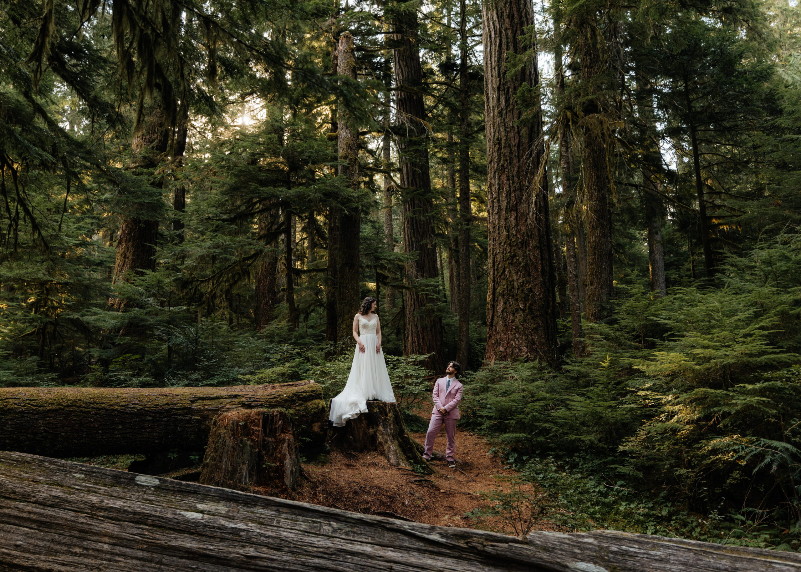 Newlyweds stand in a forest clearing during their fall elopement at Mt. Rainier National Park.
