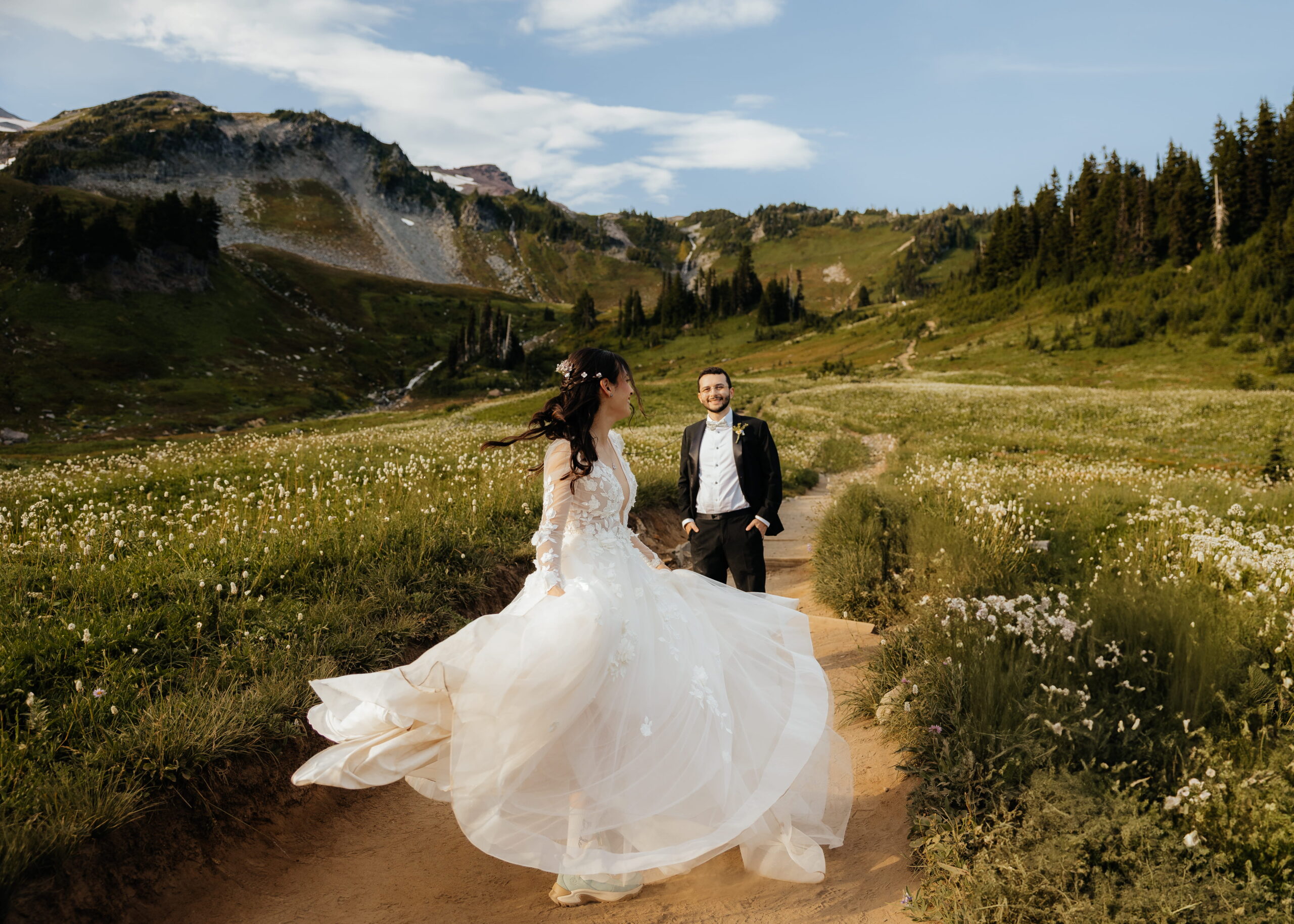 Newlyweds dance on a hiking trail during their summer Mt. Rainier elopement.