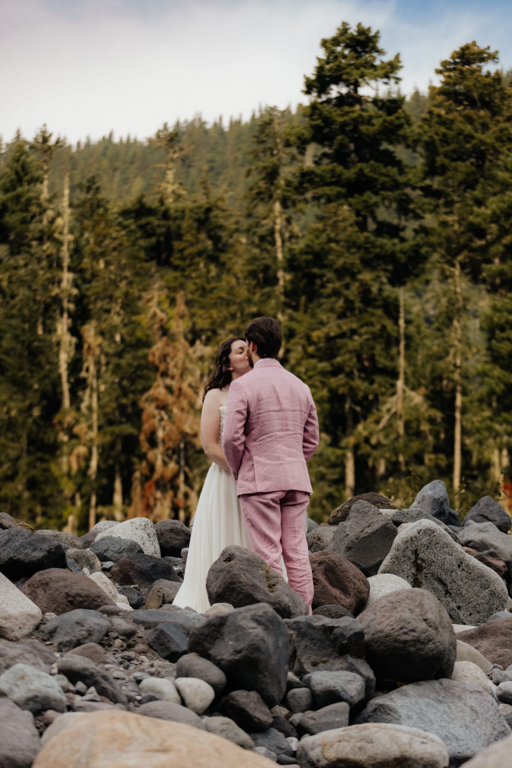Newlyweds kiss on rocks during their fall elopement at Mount Rainier National Park.