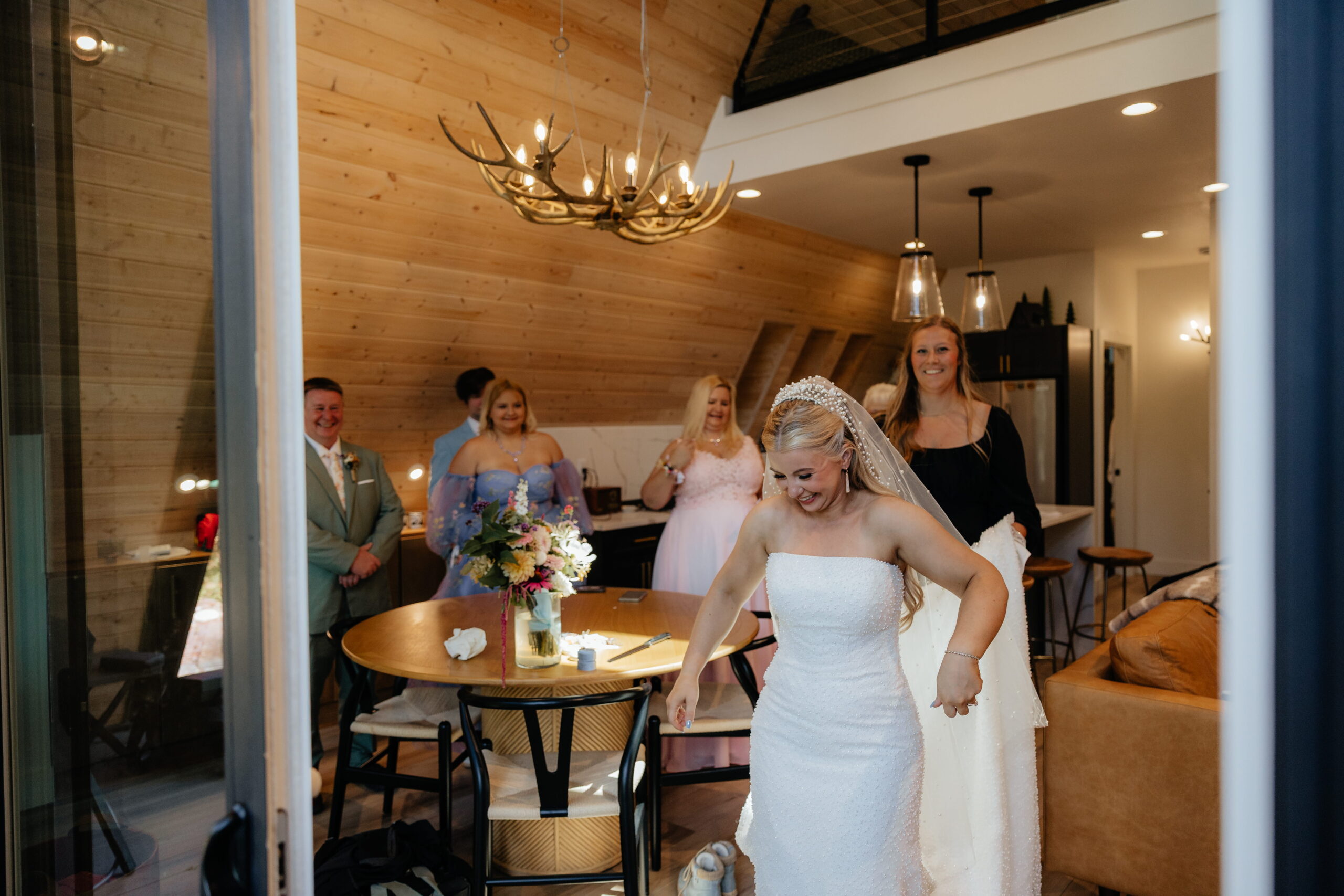 Bride exits an A-frame cabin for her first look with groom.