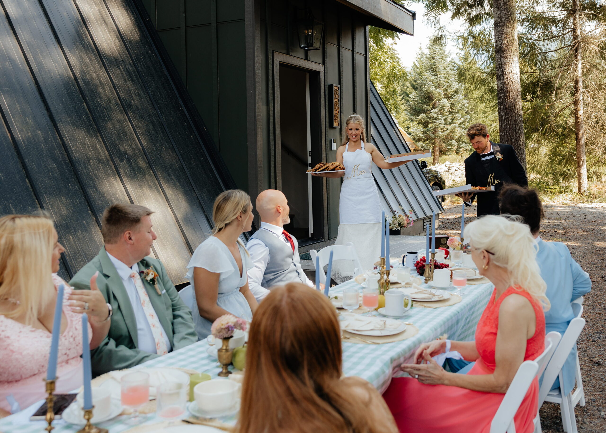 Bride and groom serve guests pizza at their wedding reception near Mt. Rainier National Park.
