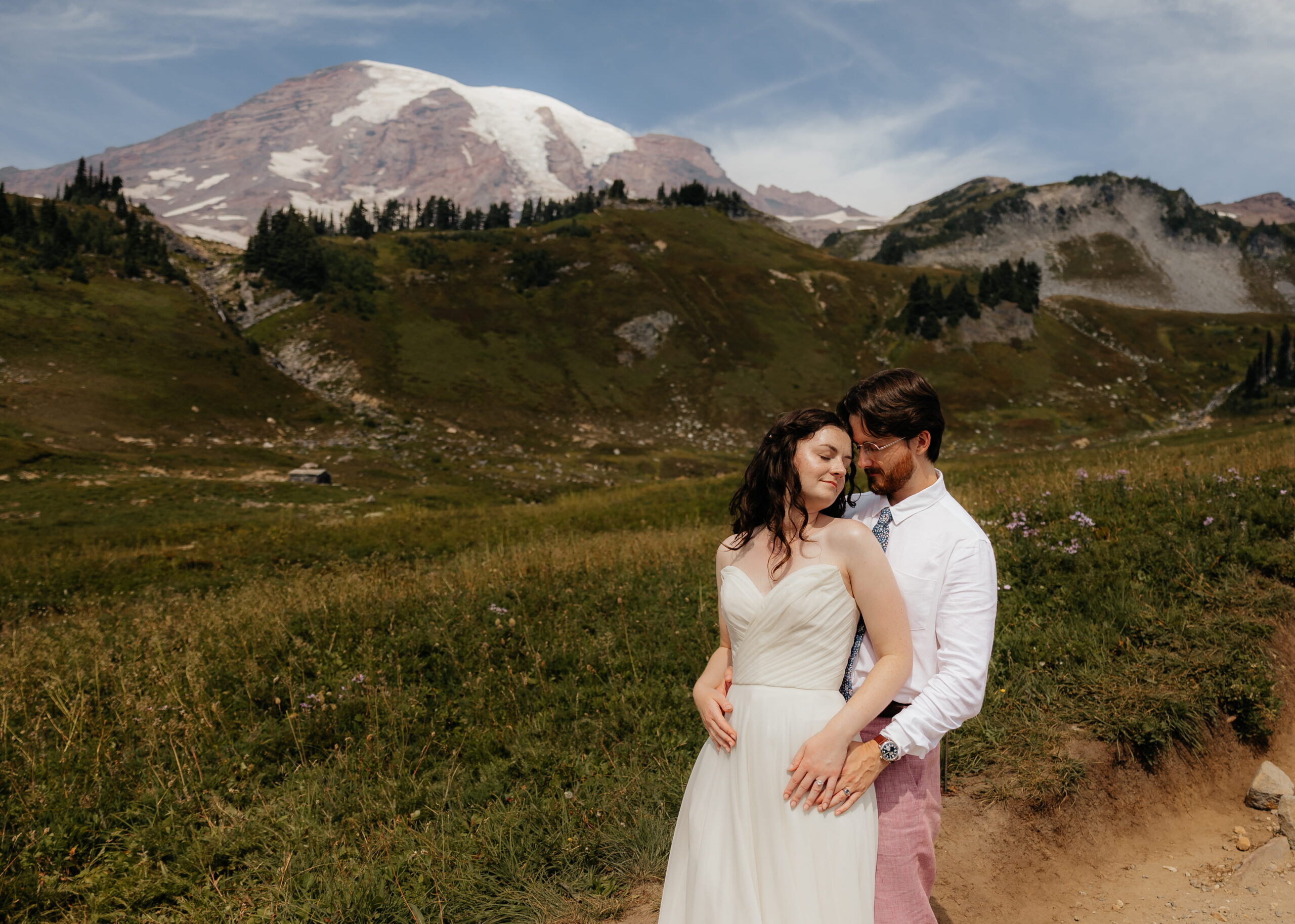 Bride and groom hug in front of Mt. Rainier.