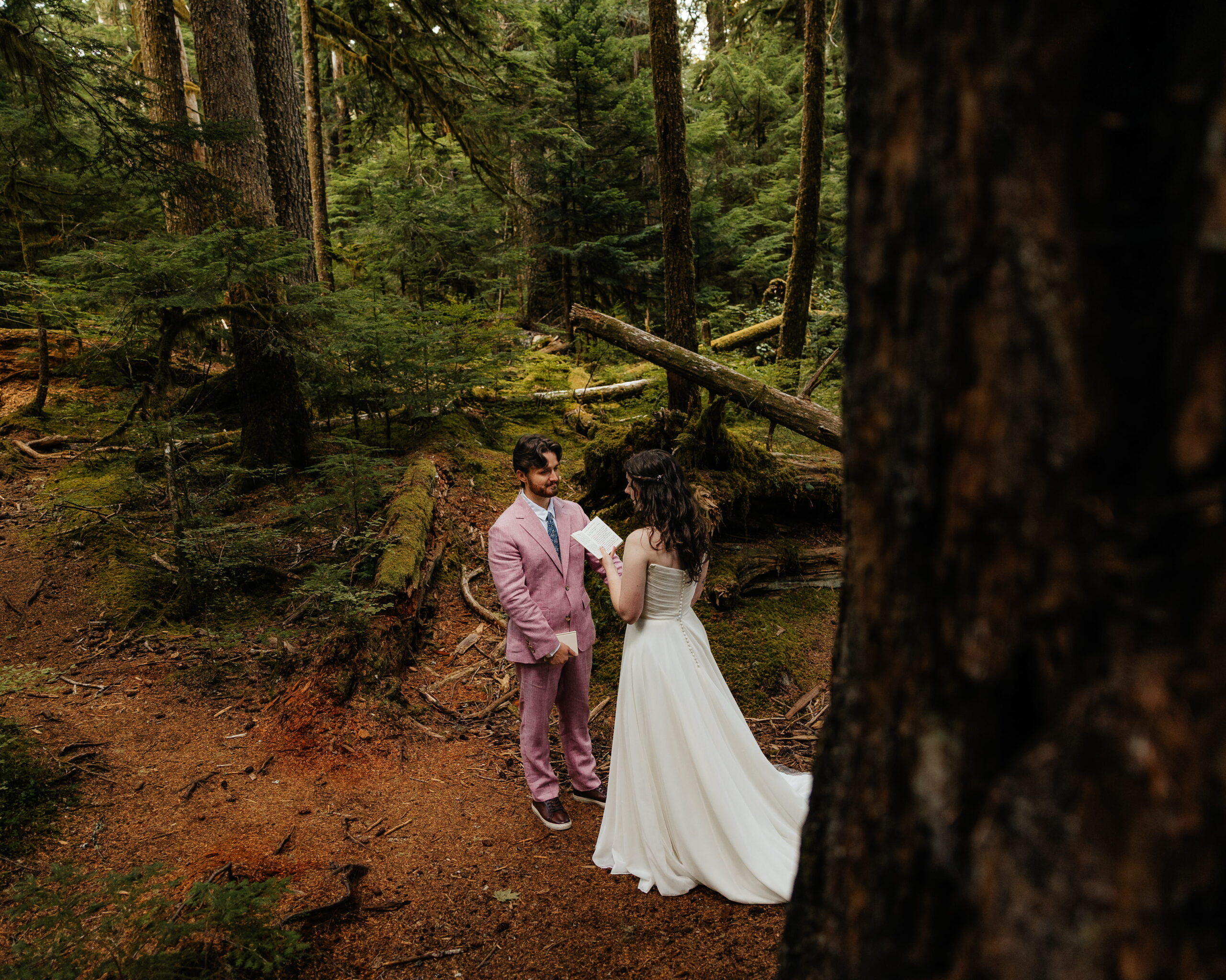 Bride reads private vows to groom in the forest during their elopement wedding in Mt. Rainier National Park.